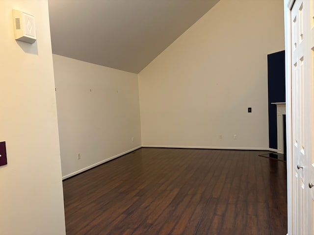 spare room with vaulted ceiling and dark hardwood / wood-style floors