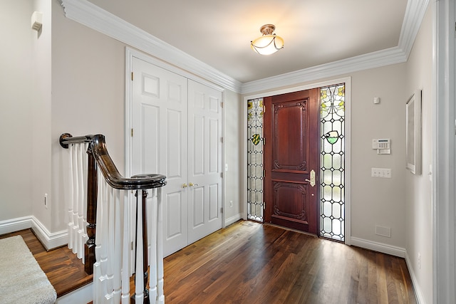 foyer entrance with dark wood-type flooring and crown molding