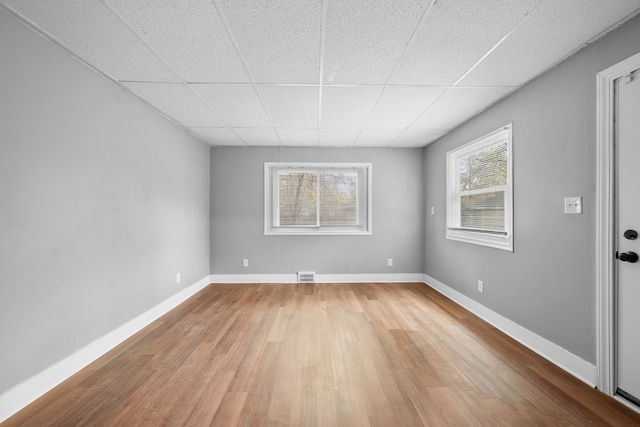 spare room with light wood-type flooring and a drop ceiling