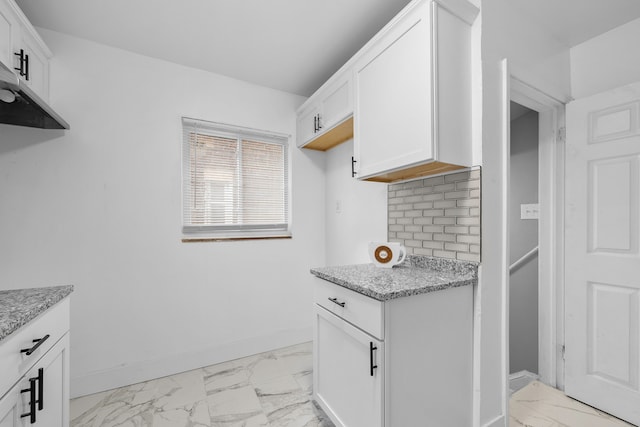 kitchen with white cabinets, decorative backsplash, and light stone counters