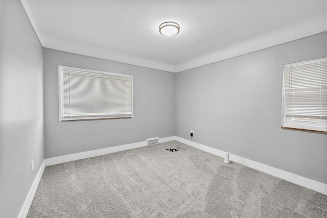 carpeted spare room featuring a wealth of natural light