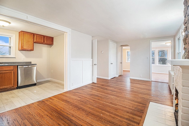 kitchen with stainless steel dishwasher, light hardwood / wood-style flooring, and a wealth of natural light