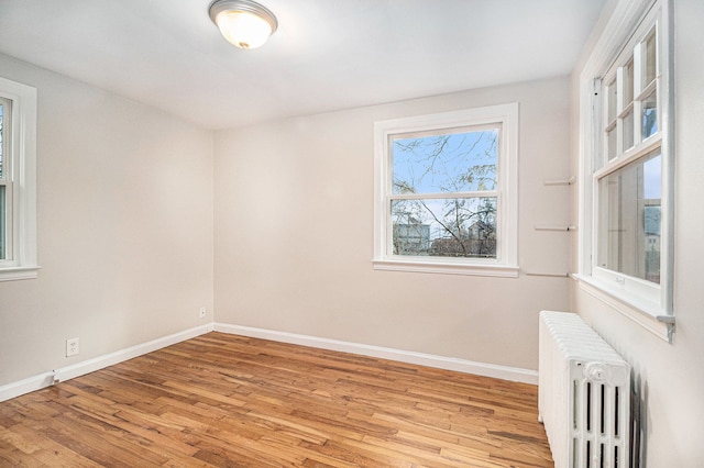 spare room with radiator and light hardwood / wood-style floors