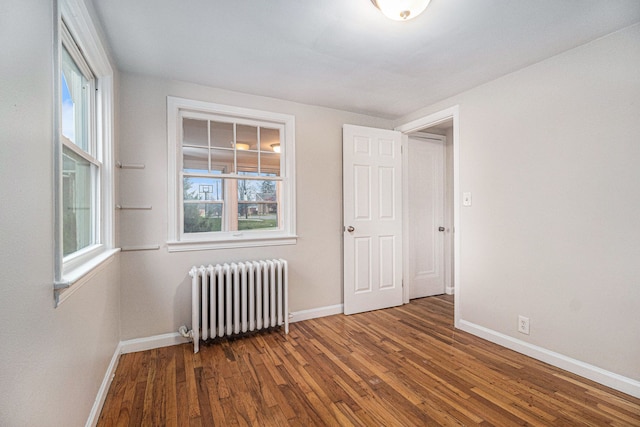 unfurnished room with radiator and hardwood / wood-style floors