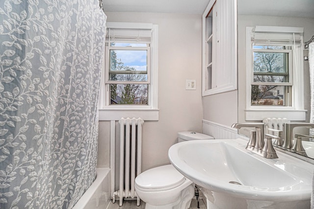 full bathroom with shower / tub combo, radiator, sink, and toilet