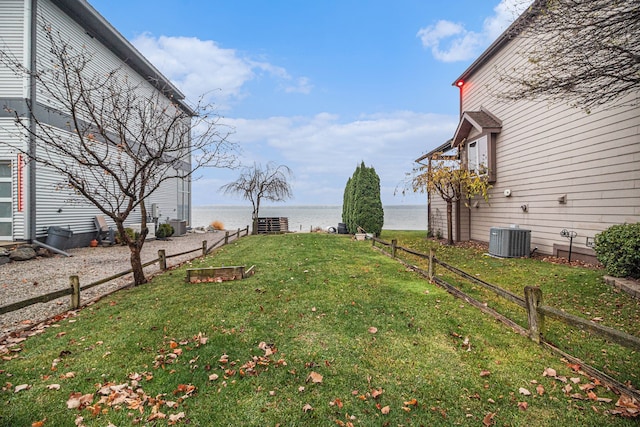 view of yard featuring a water view and central air condition unit