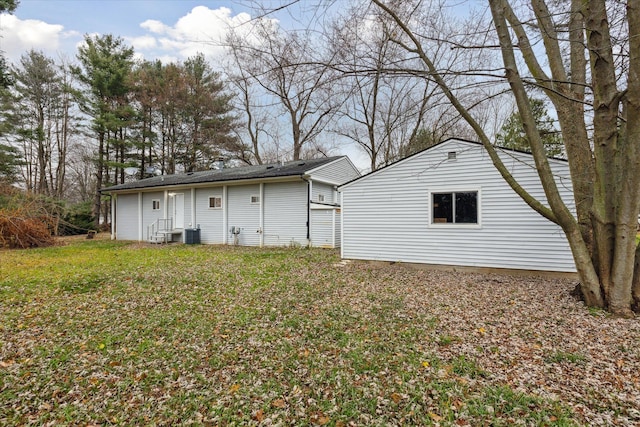 back of house with a lawn and central air condition unit