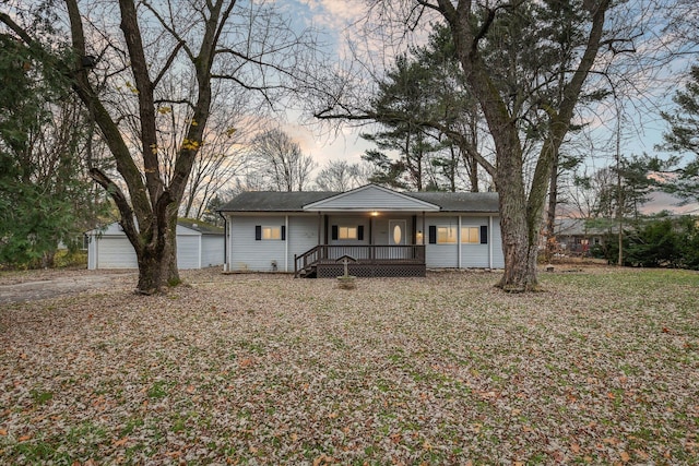 view of front facade featuring a porch, a garage, and an outbuilding