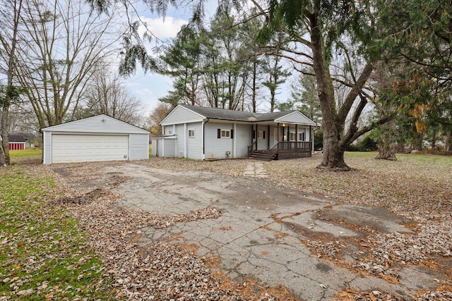 view of front of house with covered porch, a garage, and an outbuilding