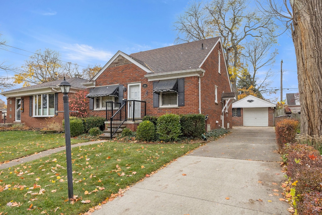 view of front of property featuring a front lawn, an outdoor structure, and a garage