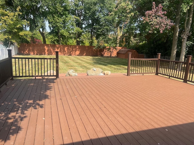 wooden deck featuring a yard and a storage shed