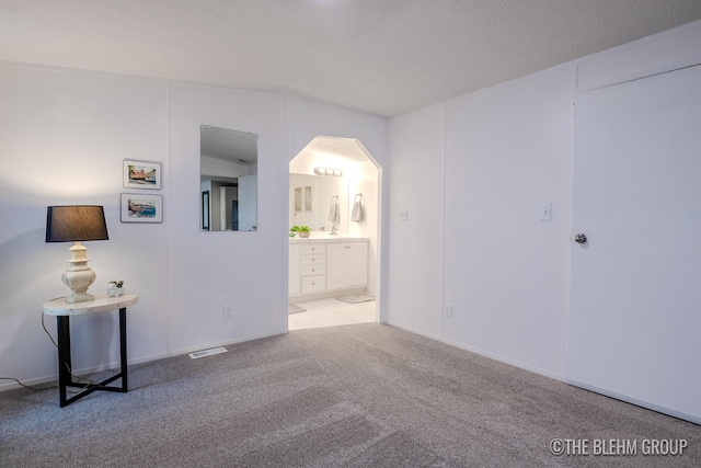 unfurnished room with light carpet and a textured ceiling