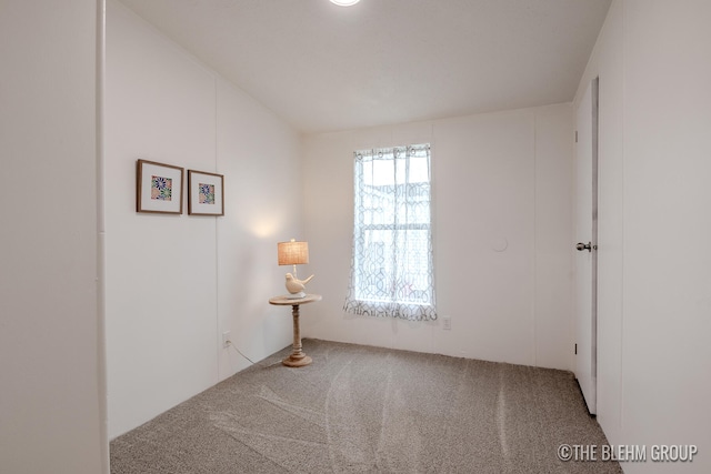 unfurnished room featuring carpet and vaulted ceiling