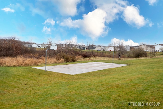 view of sport court with a lawn