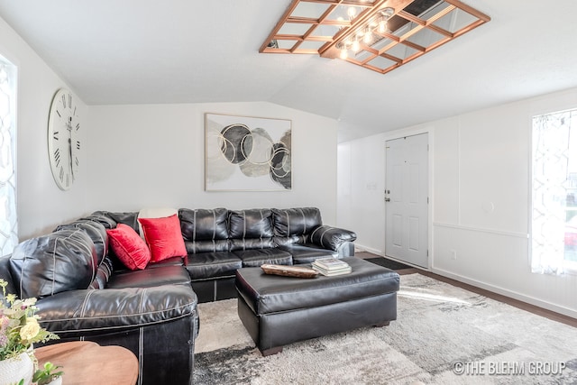 living room with a healthy amount of sunlight, vaulted ceiling, and wood-type flooring