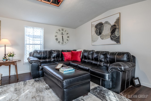 living room with a textured ceiling, dark wood-type flooring, and vaulted ceiling