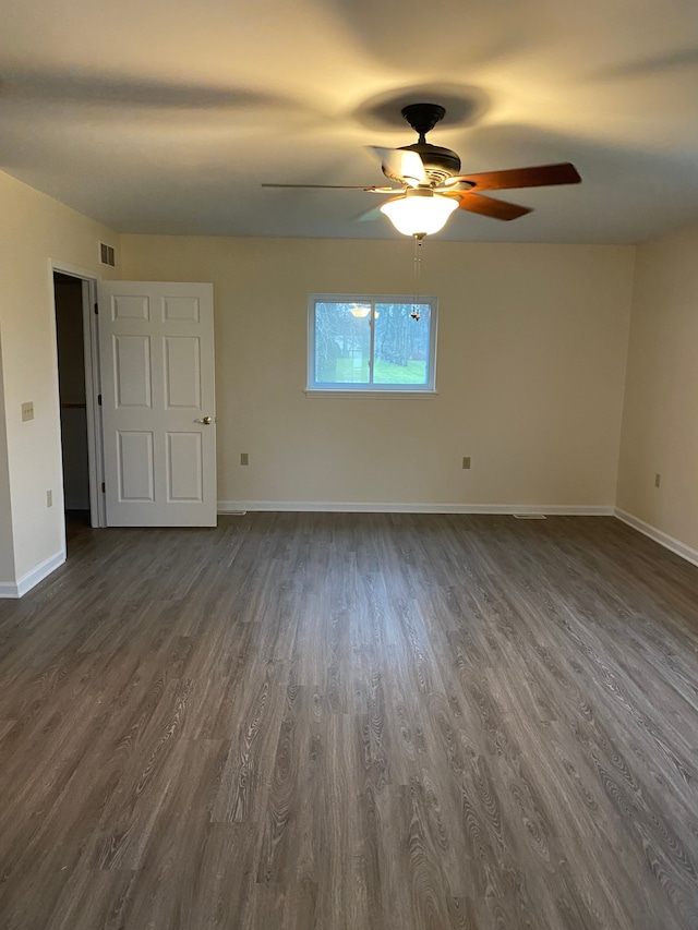 empty room with dark hardwood / wood-style floors and ceiling fan