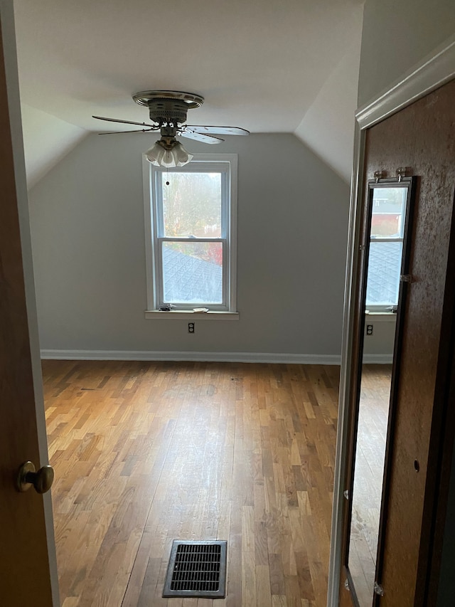 additional living space with ceiling fan, vaulted ceiling, and hardwood / wood-style flooring