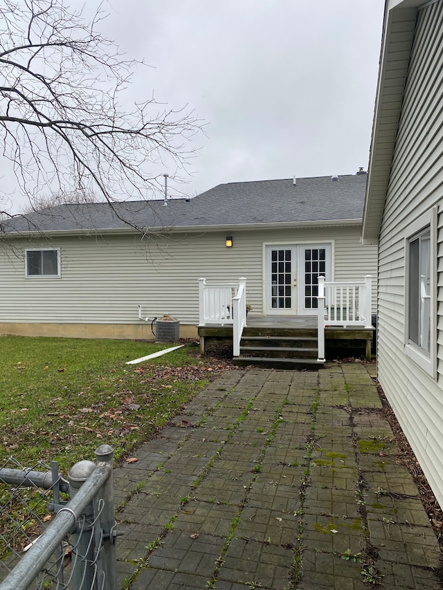 rear view of property with a wooden deck, french doors, and central AC unit