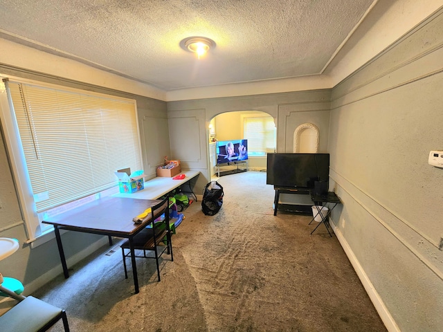 carpeted dining space with a textured ceiling