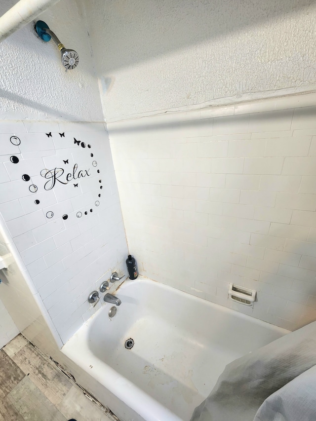 bathroom with hardwood / wood-style floors and tiled shower / bath combo