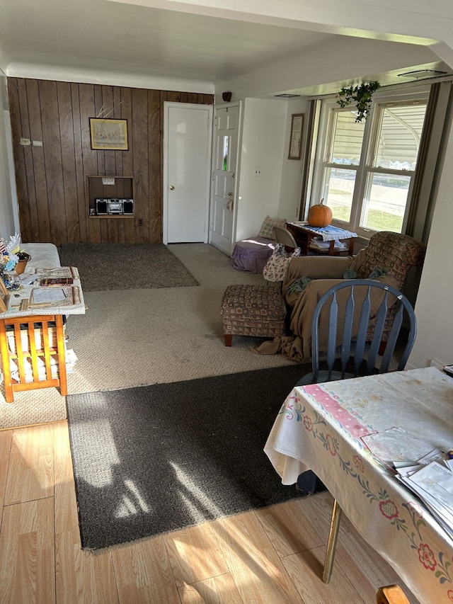 living room featuring light wood-type flooring and wood walls