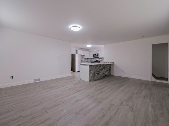 unfurnished living room with light hardwood / wood-style flooring