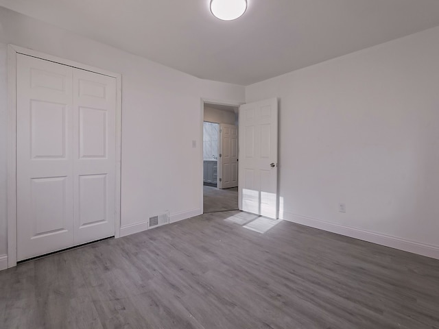 unfurnished bedroom featuring light wood-type flooring and a closet