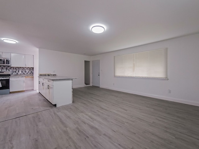 kitchen featuring light hardwood / wood-style flooring, decorative backsplash, white cabinetry, kitchen peninsula, and stainless steel appliances