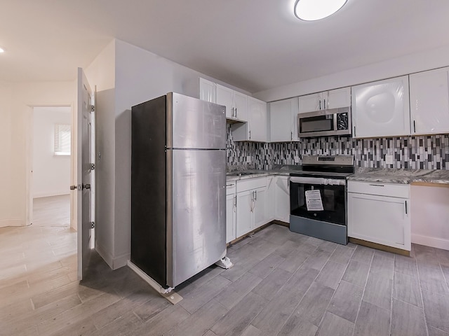 kitchen with light stone countertops, white cabinets, and appliances with stainless steel finishes