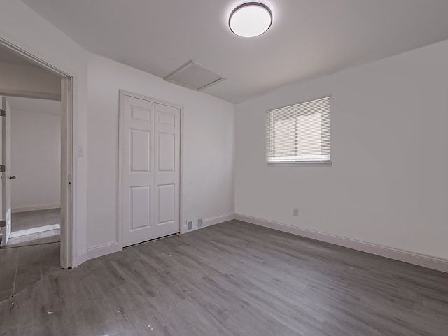 unfurnished bedroom with wood-type flooring and a closet