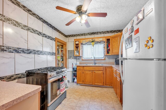 8459 Timken Ave, Warren, MI 48089 - kitchen featuring freestanding refrigerator, stainless steel range with gas stovetop, a sink, a ceiling fan, and light countertops