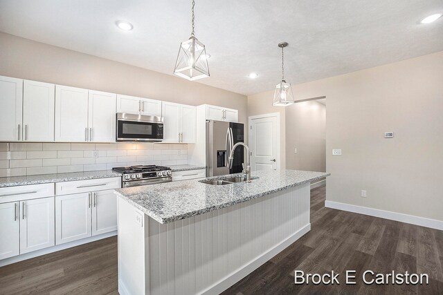 kitchen with white cabinetry, sink, stainless steel appliances, dark hardwood / wood-style flooring, and a center island with sink