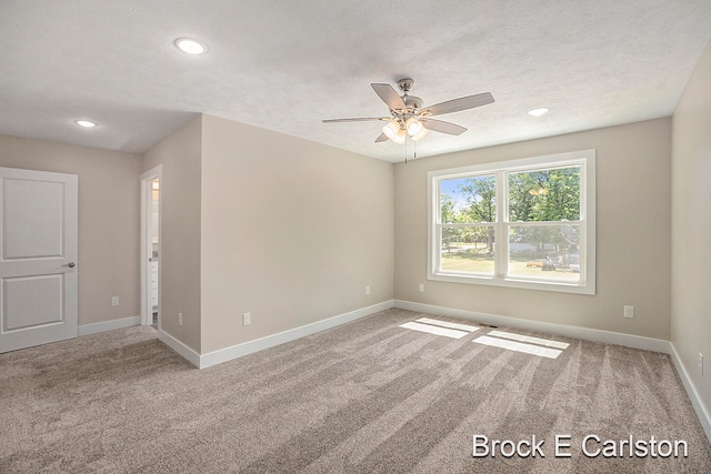 spare room featuring ceiling fan, carpet floors, and a textured ceiling