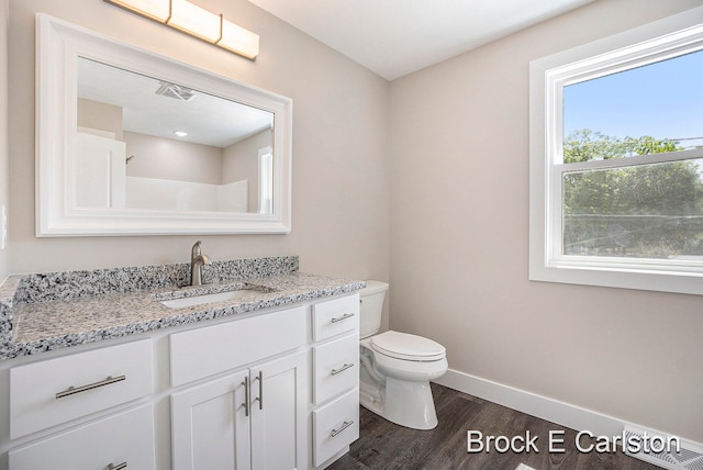 bathroom featuring wood-type flooring, vanity, and toilet