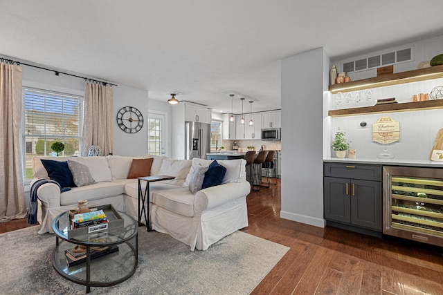 living room featuring indoor bar, dark hardwood / wood-style floors, and wine cooler