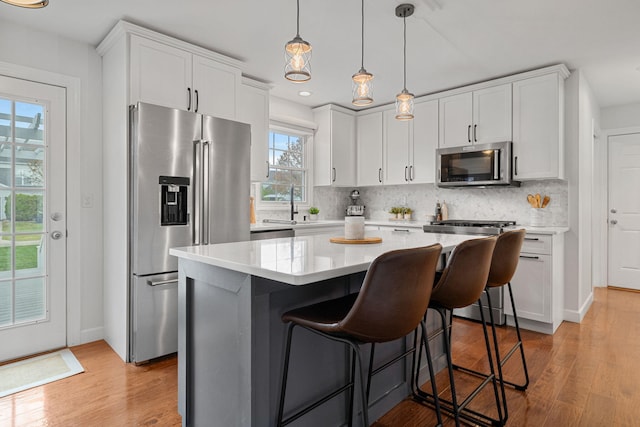 kitchen with plenty of natural light, white cabinets, and stainless steel appliances