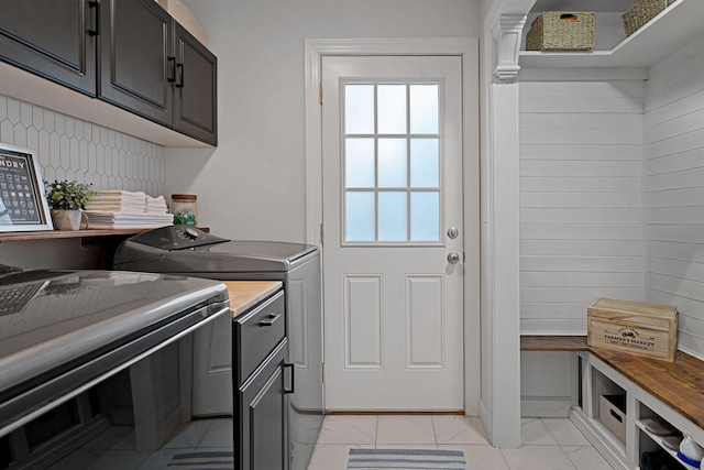 washroom with washer and dryer and cabinets