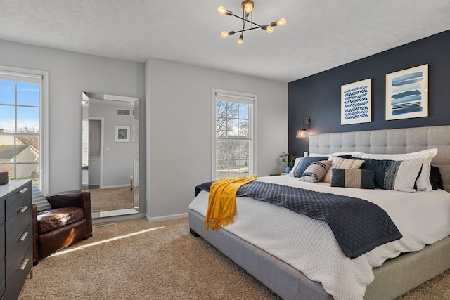 bedroom with carpet, a textured ceiling, and an inviting chandelier