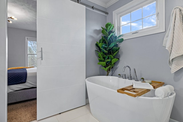 bathroom featuring a tub, tile patterned flooring, a healthy amount of sunlight, and a textured ceiling