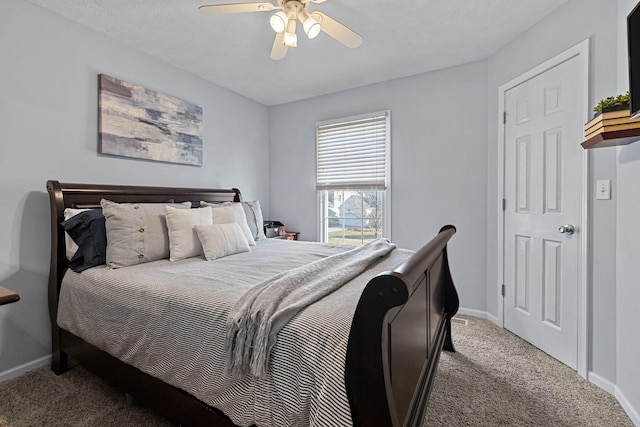 bedroom featuring a textured ceiling, light colored carpet, and ceiling fan