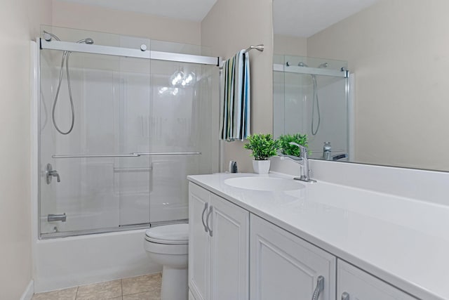 full bathroom featuring tile patterned flooring, vanity, bath / shower combo with glass door, and toilet