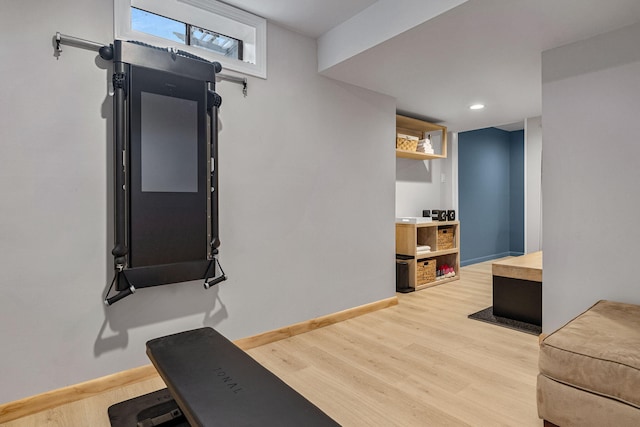 workout area with light hardwood / wood-style flooring