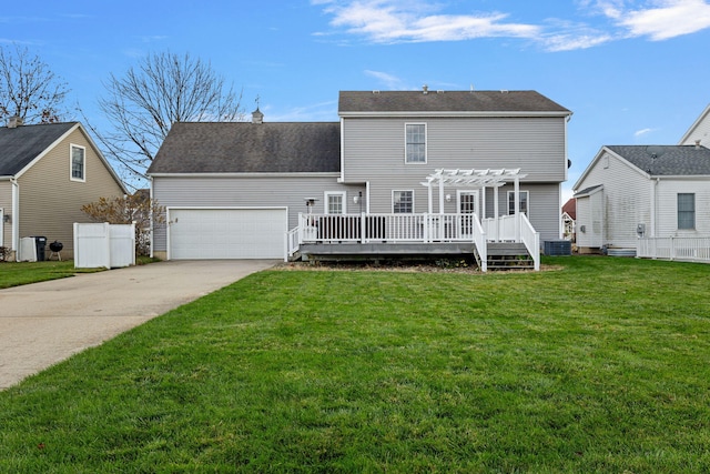 rear view of property featuring a pergola, a wooden deck, a lawn, and a garage