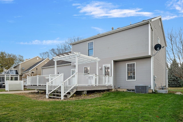 back of property with a pergola, a deck, cooling unit, and a lawn