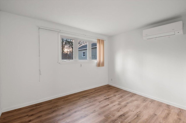 14402 90th Ave, Mecosta, MI 49332 - unfurnished room featuring a wall mounted AC, wood finished floors, and baseboards