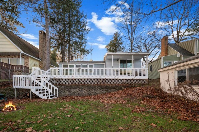 14402 90th Ave, Mecosta, MI 49332 - rear view of property featuring a wooden deck, a fire pit, stairs, a yard, and a sunroom