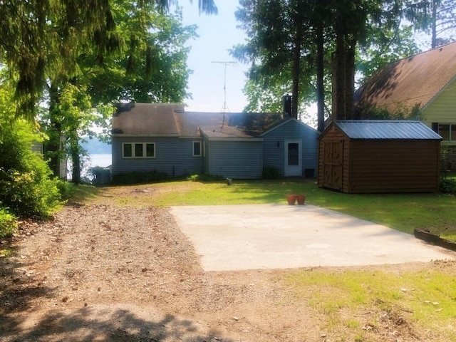 14402 90th Ave, Mecosta, MI 49332 - back of house featuring a storage unit, a yard, and a patio area