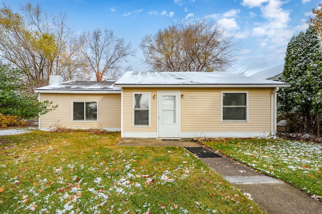 back of property featuring a yard