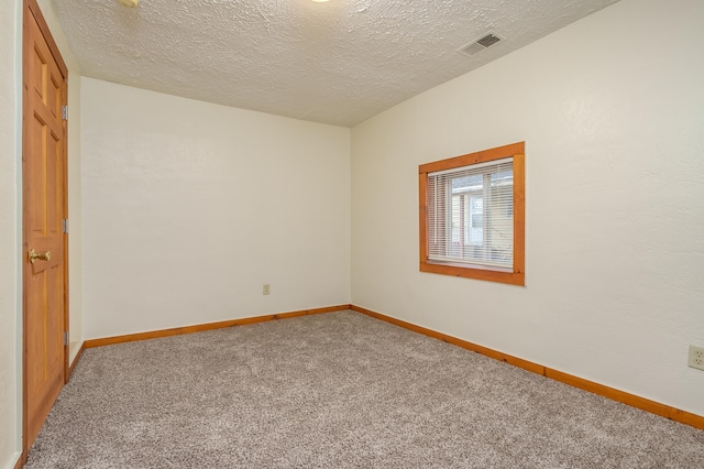 carpeted spare room with a textured ceiling